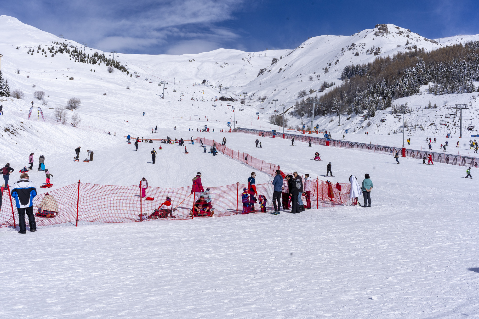 Skieurs sur les pistes enneigées sous un ciel bleu